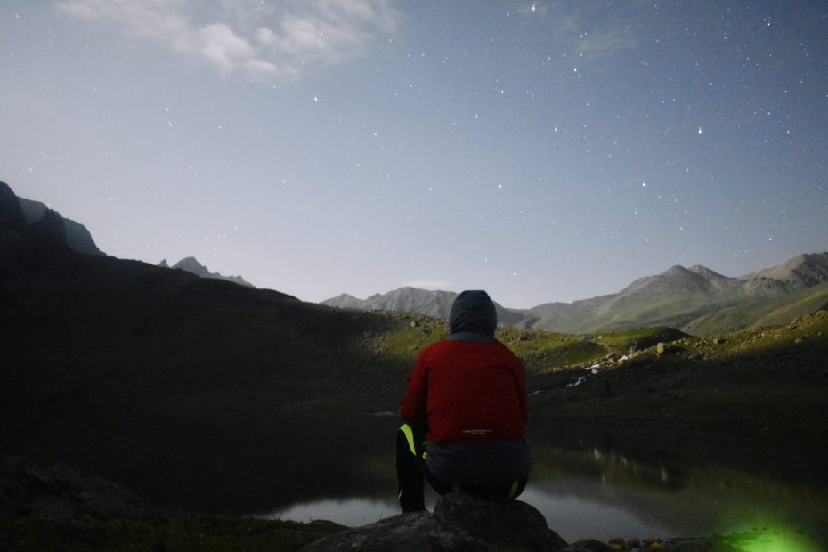 Personnes observant les étoiles depuis un sommet montagneux en France, sous un ciel nocturne dégagé.