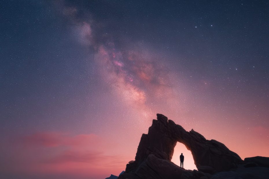 Une personne observe un ciel étoilé depuis un site montagneux éloigné des lumières urbaines.